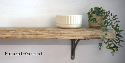 A rustic wooden shelf mounted on a white wall, with a cream-colored ribbed bowl on top and a green trailing plant in a woven pot. The text 'Natural-Oatmeal' is displayed in the lower-left corner.